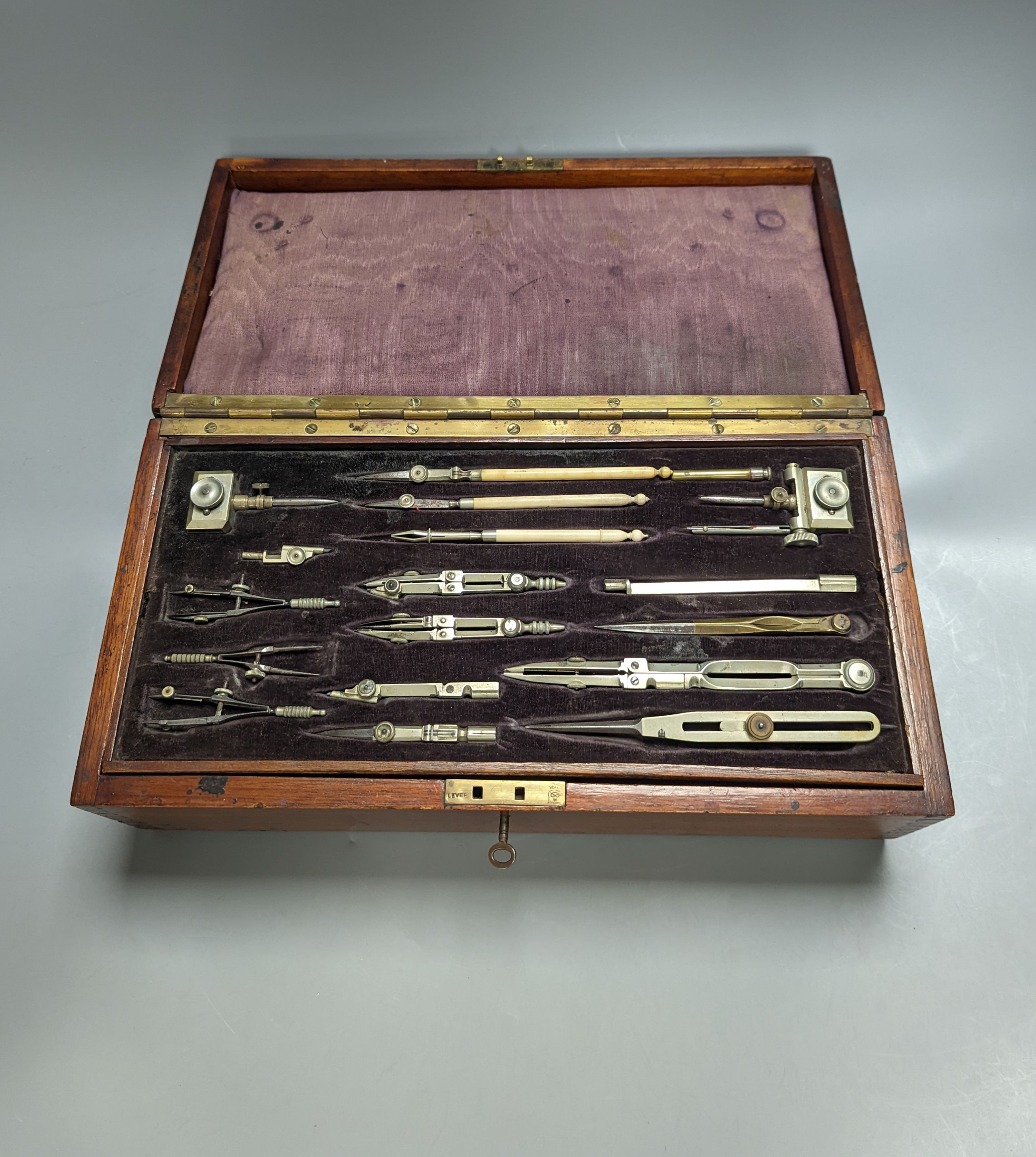 An early 20th century large mahogany case of electrum drawing instruments, wood squares and rulers, 37 x 18.5cm, incomplete